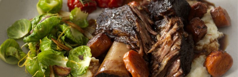 Short ribs with mashed potatoes and vegetables on side