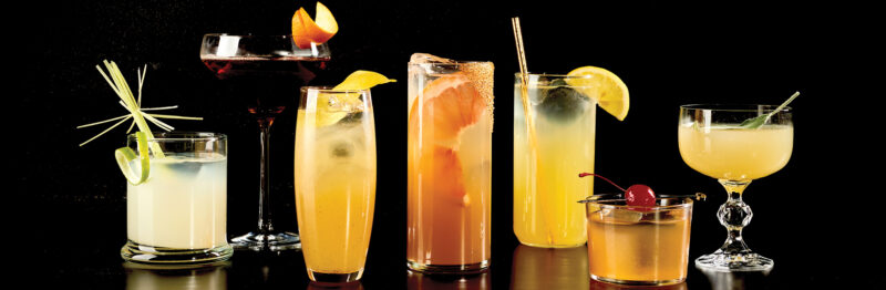 Seven mocktails on a black background