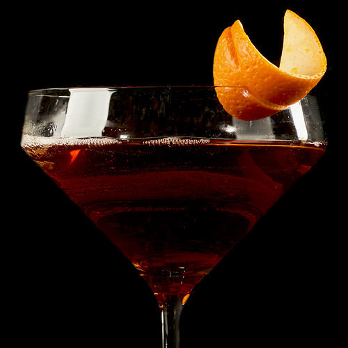 Virgin Manhattan with nonalcoholic whiskey, cranberry juice, maraschino cherry juice, lemon juice, angostura bitters and orange peel garnish.